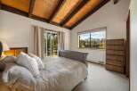 This stunning bedroom boasts a vaulted, wood-paneled ceiling and a cozy, inviting atmosphere.
