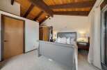 This stunning bedroom boasts a unique wooden ceiling with exposed beams, creating a warm and inviting atmosphere.