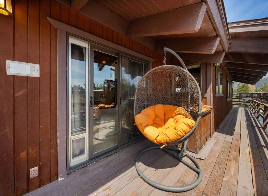 Relax and unwind in this stunning outdoor space! Featuring a cozy hanging chair with a vibrant orange cushion, this area is perfect for enjoying the fresh air and sunshine.