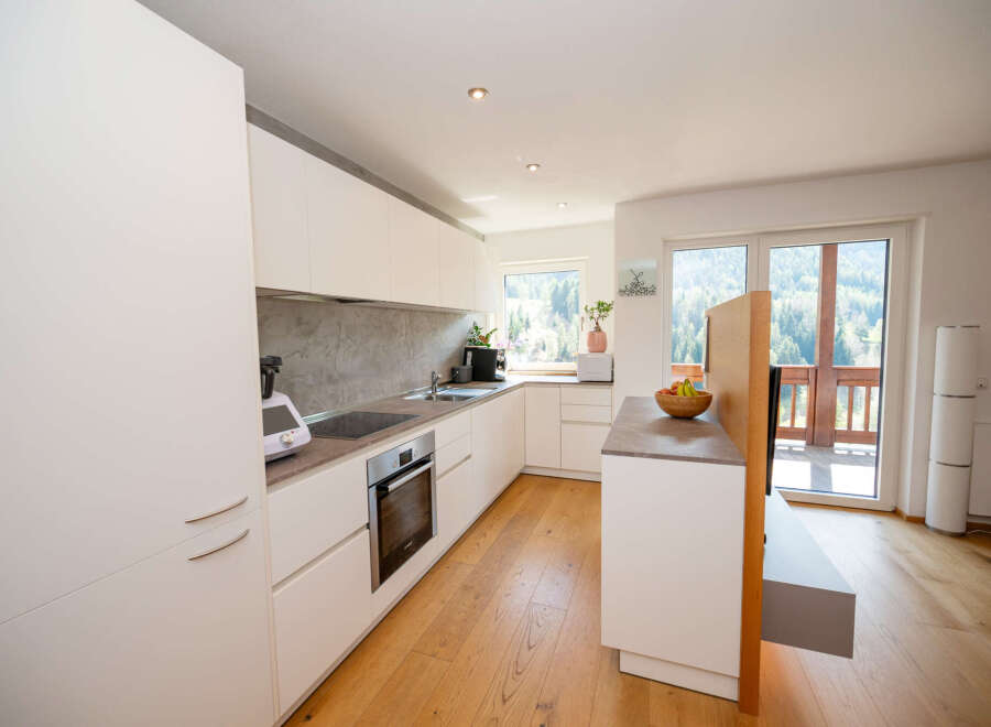 This modern kitchen boasts sleek white cabinetry, offering ample storage and a clean aesthetic.