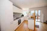 This modern kitchen boasts sleek white cabinetry, offering ample storage and a clean aesthetic.