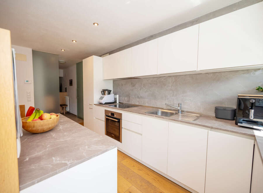 This modern kitchen boasts sleek white cabinetry and a stylish countertop, creating a bright and inviting space.