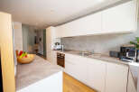 This modern kitchen boasts sleek white cabinetry and a stylish countertop, creating a bright and inviting space.