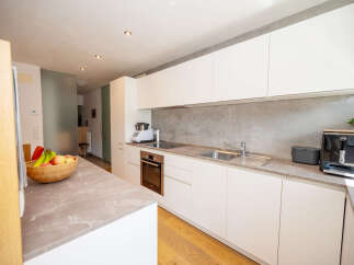 This modern kitchen boasts sleek white cabinetry and a stylish countertop, creating a bright and inviting space.
