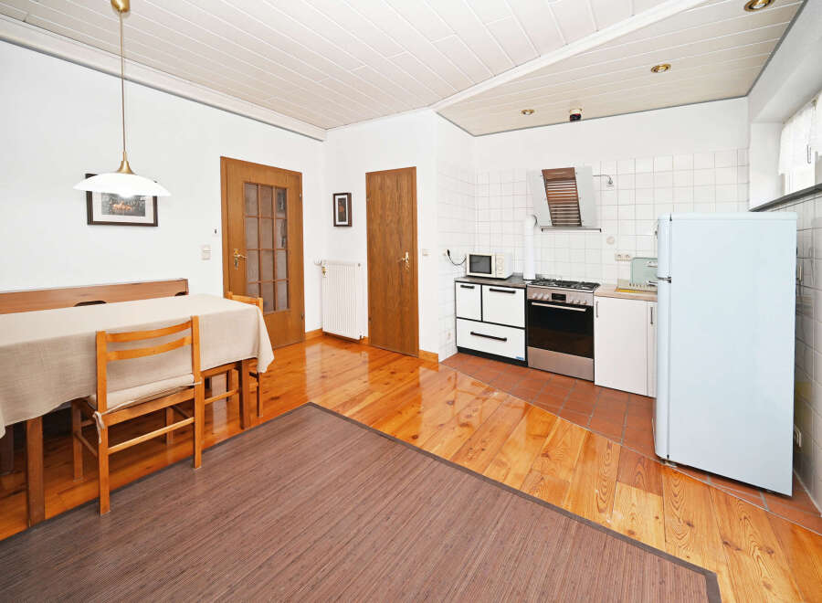 This charming property features a bright and airy kitchen with a classic stove and refrigerator, perfect for culinary enthusiasts.