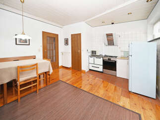 This charming property features a bright and airy kitchen with a classic stove and refrigerator, perfect for culinary enthusiasts.