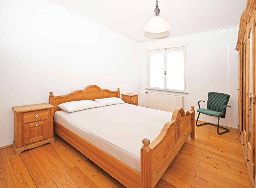 This charming bedroom features a classic wooden bed frame, complemented by matching nightstands.