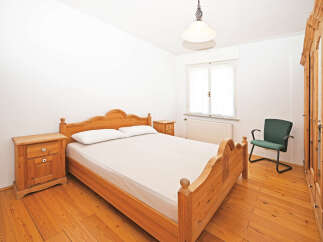 This charming bedroom features a classic wooden bed frame, complemented by matching nightstands.