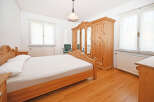 This charming bedroom features a warm, inviting atmosphere with its wooden furniture and flooring.