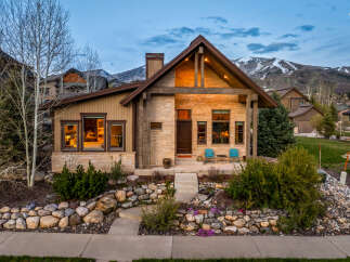 This stunning home boasts a beautiful stone facade and a welcoming front porch, perfect for enjoying the mountain views.