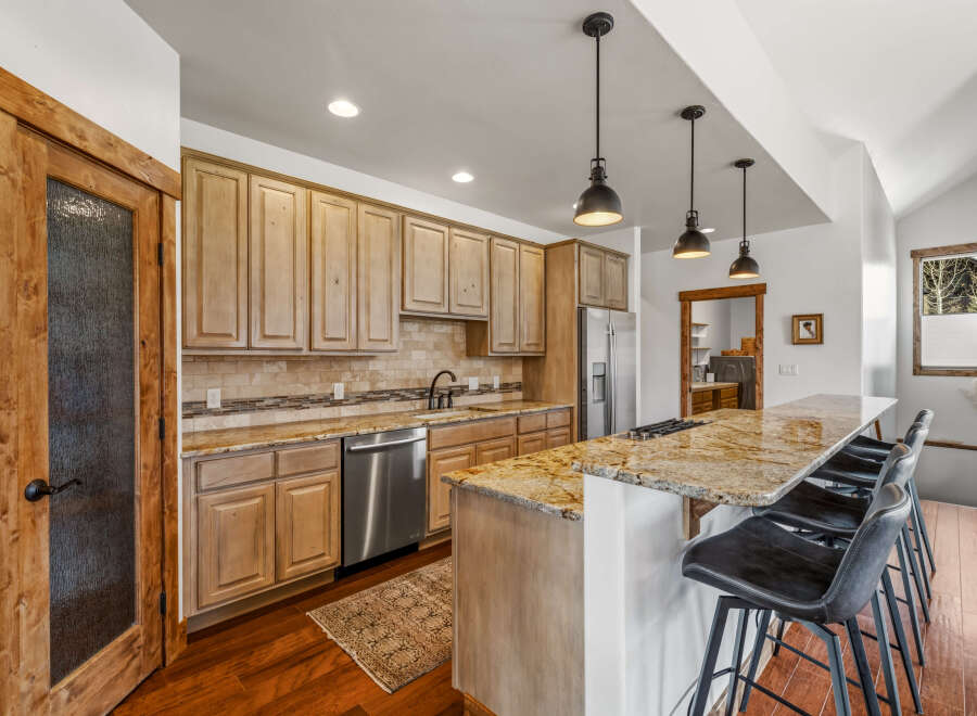 This stunning kitchen boasts a beautiful granite countertop and a stylish breakfast bar, perfect for entertaining.