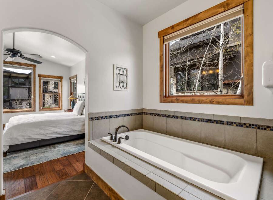 This luxurious bathroom features a pristine white bathtub, perfect for relaxation.