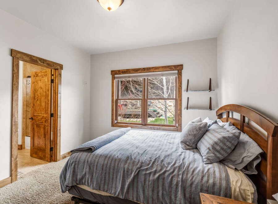 This cozy bedroom features a comfortable bed with soft pillows and a stylish wooden headboard.