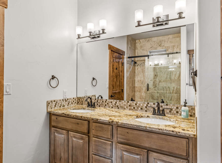 This luxurious bathroom features a stunning granite countertop with dual sinks, perfect for a couple.