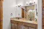 This luxurious bathroom features a stunning granite countertop with dual sinks, perfect for a couple.