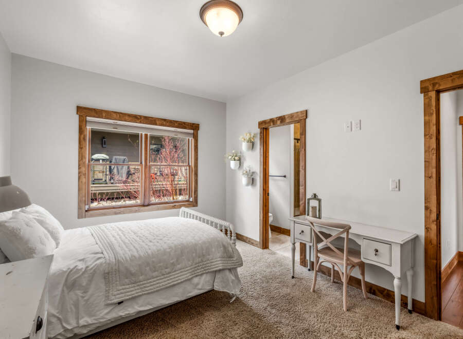 This charming bedroom features a cozy ambiance with its soft, neutral color palette and inviting textures.