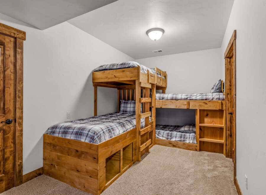 This cozy bedroom features custom-built bunk beds, perfect for a vacation home or a kid's room.