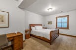 This cozy bedroom features a beautiful wooden bed frame and a comfortable, inviting atmosphere.