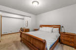 This inviting bedroom features a classic wooden bed frame, offering a warm and traditional aesthetic.