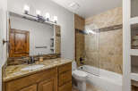 This stunning bathroom boasts a luxurious design with a granite countertop and a stylish vanity.