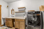 This laundry room features a modern design with a Maytag washing machine and ample counter space.
