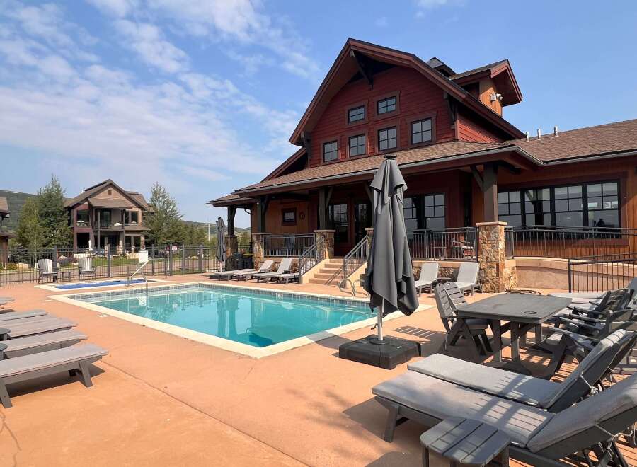 Enjoy luxurious living at this stunning property featuring a beautiful outdoor pool and a charming, rustic-style building.
