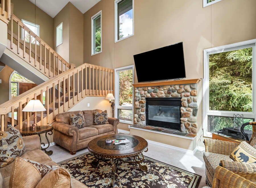 Step into luxury with this stunning living room, featuring a cozy fireplace and a large flat-screen TV, perfect for entertaining.