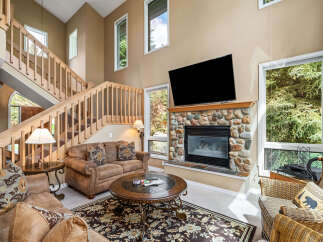 Step into luxury with this stunning living room, featuring a cozy fireplace and a large flat-screen TV, perfect for entertaining.