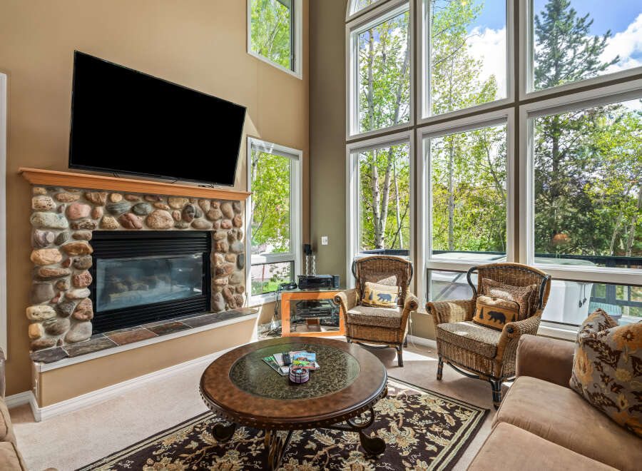 This stunning living room boasts a cozy fireplace with a stone facade, perfect for chilly evenings.