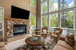 This stunning living room boasts a cozy fireplace with a stone facade, perfect for chilly evenings.