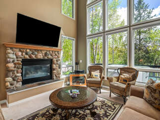 This stunning living room boasts a cozy fireplace with a stone facade, perfect for chilly evenings.