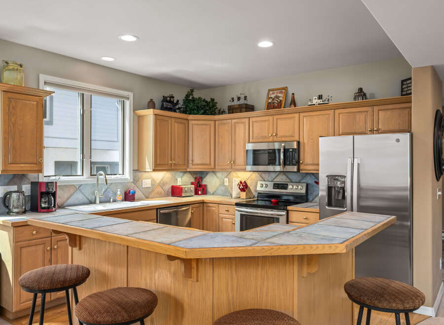 This stunning kitchen boasts a spacious layout with ample counter space and cabinetry, perfect for culinary enthusiasts.