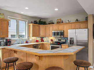 This stunning kitchen boasts a spacious layout with ample counter space and cabinetry, perfect for culinary enthusiasts.