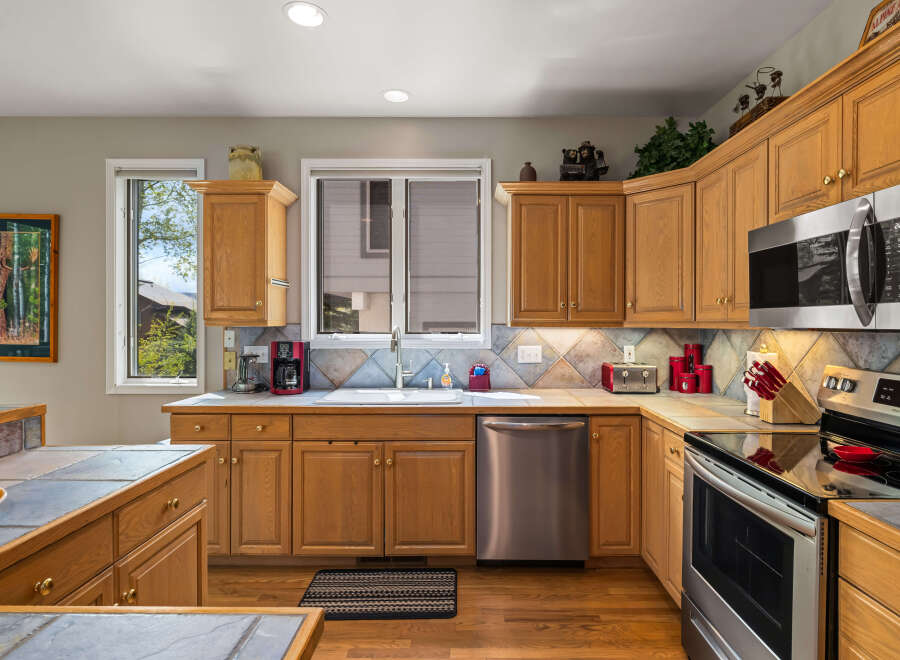 This stunning kitchen boasts beautiful wooden cabinetry and sleek stainless steel appliances, creating a warm and inviting atmosphere.