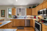 This stunning kitchen boasts beautiful wooden cabinetry and sleek stainless steel appliances, creating a warm and inviting atmosphere.