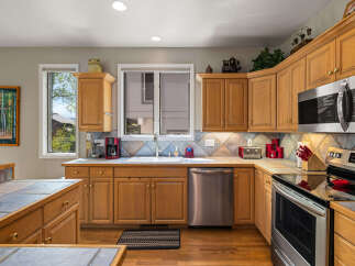 This stunning kitchen boasts beautiful wooden cabinetry and sleek stainless steel appliances, creating a warm and inviting atmosphere.