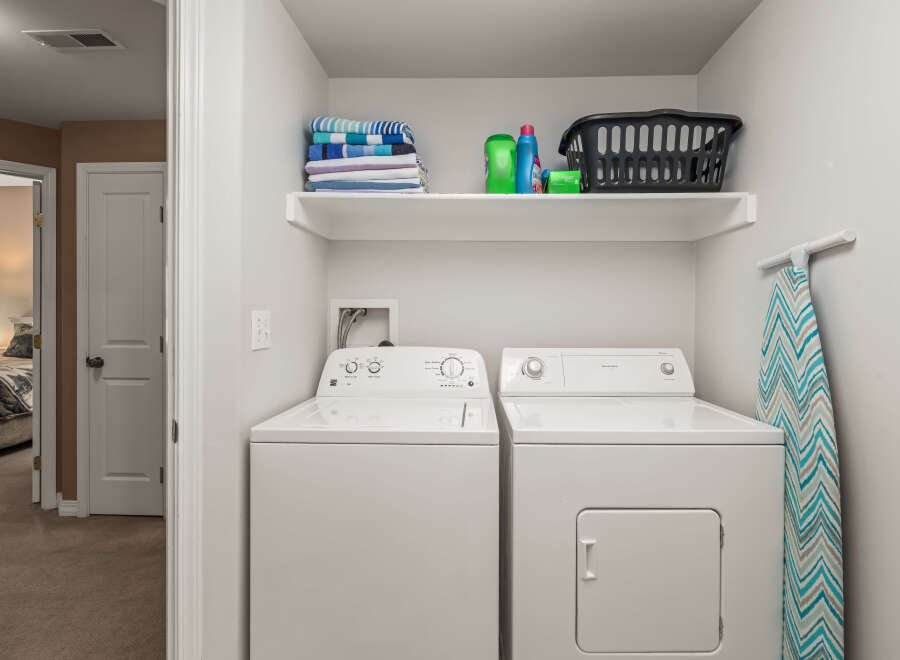 This laundry room features a modern design with a white washer and dryer set.