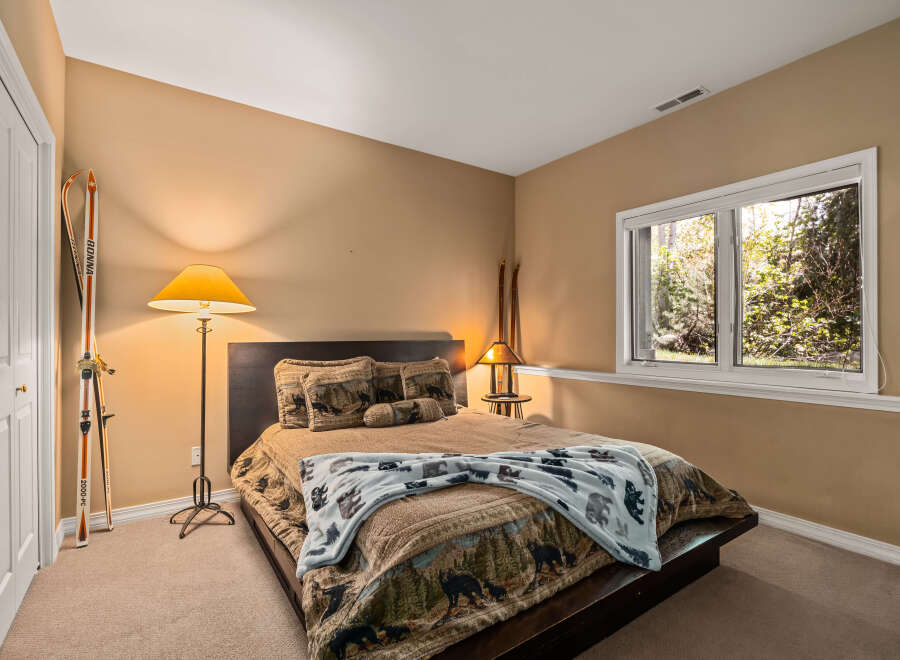 This cozy bedroom features a comfortable bed with a unique quilt and decorative pillows.