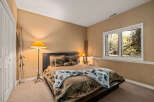 This cozy bedroom features a comfortable bed with a unique quilt and decorative pillows.