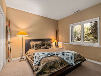 This cozy bedroom features a comfortable bed with a unique quilt and decorative pillows.