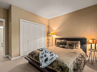 This cozy bedroom features a rustic design with a comfortable bed and warm lighting.