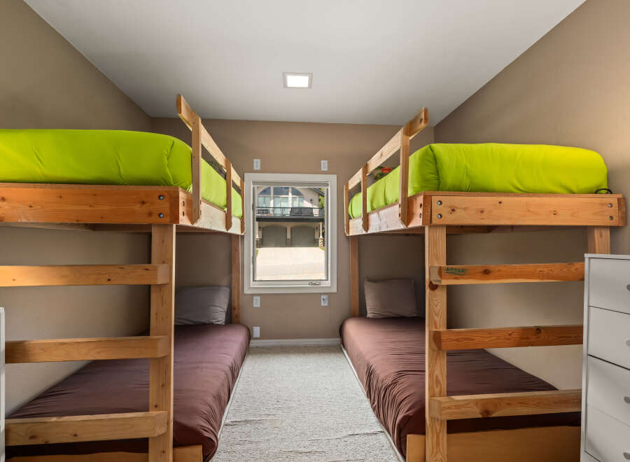 This cozy bedroom features two sets of bunk beds, perfect for accommodating multiple guests or family members.
