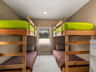 This cozy bedroom features two sets of bunk beds, perfect for accommodating multiple guests or family members.
