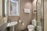 This bathroom features a modern design with a pedestal sink and a sleek glass shower enclosure.