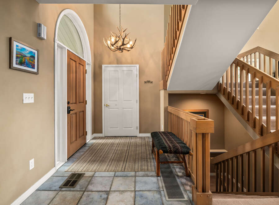 Step into this inviting entryway, showcasing a beautiful staircase and a warm, welcoming atmosphere.