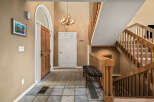 Step into this inviting entryway, showcasing a beautiful staircase and a warm, welcoming atmosphere.