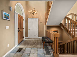 Step into this inviting entryway, showcasing a beautiful staircase and a warm, welcoming atmosphere.