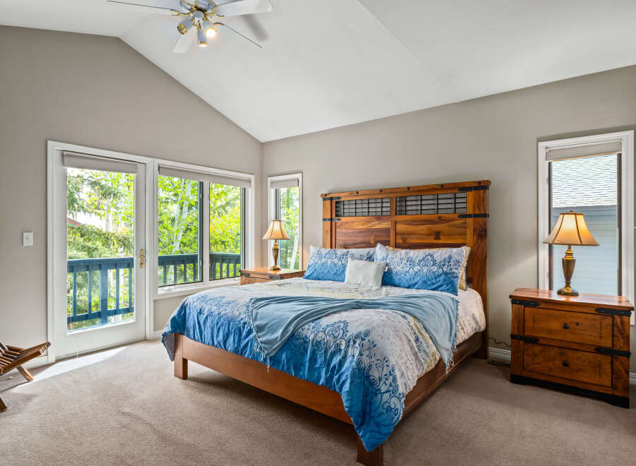 This stunning bedroom boasts a vaulted ceiling and ample natural light, creating a bright and airy atmosphere.