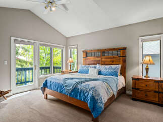 This stunning bedroom boasts a vaulted ceiling and ample natural light, creating a bright and airy atmosphere.