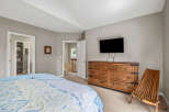 This inviting bedroom features a cozy bed with a stylish patterned comforter, perfect for relaxation.